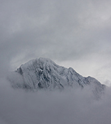 High mountain framed by clouds.